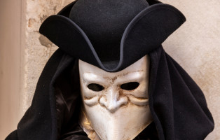 A venetian mask  and a sinister black robe in Venice